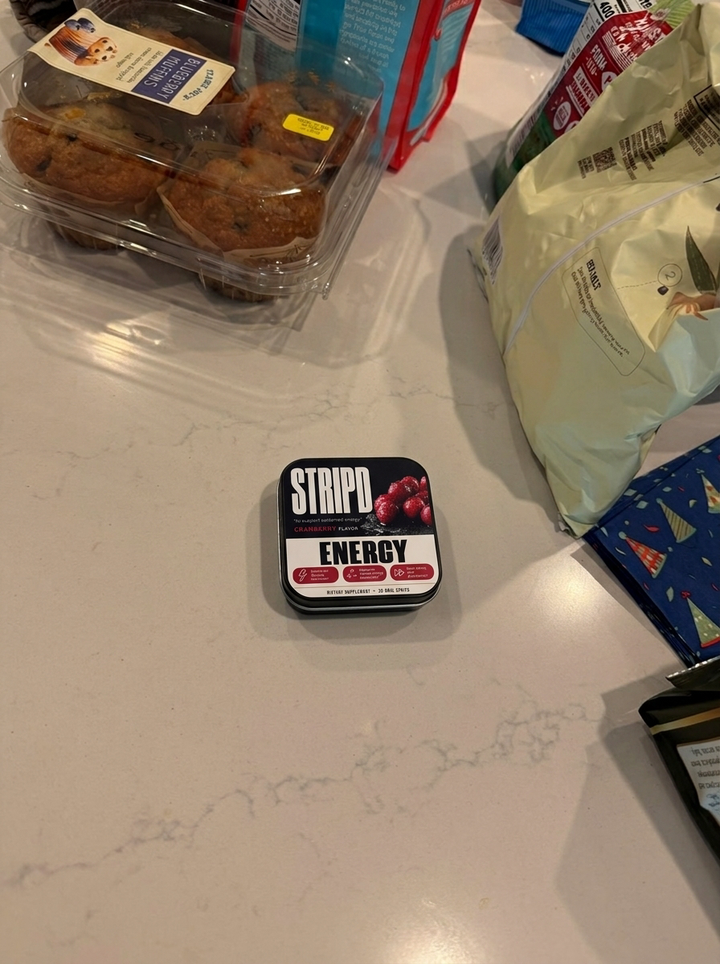 STRIPD Energy tin held in a car